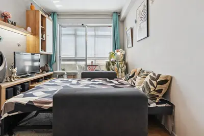 a bedroom with a bed and a tv and a window at Refugio no oPorto in Porto