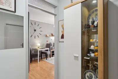 a hallway with a clock and a dining room with a table at Refugio no oPorto in Porto