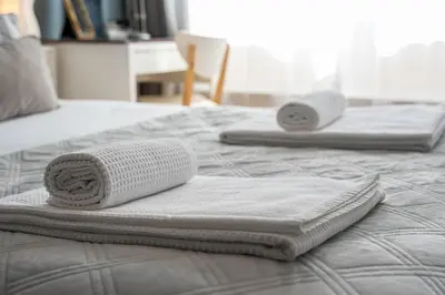 two white towels sitting on top of a bed at Refugio no oPorto in Porto