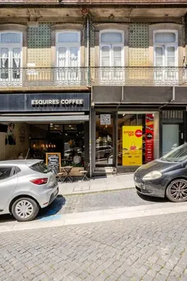 two cars parked on a street in front of a store at Modern Downtown Studio in Porto