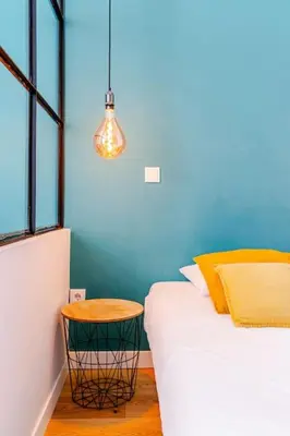 a room with a bed and a stool next to a window at Modern Downtown Studio in Porto
