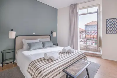 a white bedroom with a bed with towels on it at VC Heritage Ribeira Porto in Porto