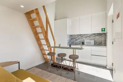 a white kitchen with a sink and a table at Beco do Paço by Porto Dream Stays in Porto