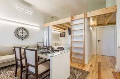 a kitchen with white cabinets and a sink and a table at Beco do Paço by Porto Dream Stays in Porto