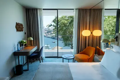 a hotel room with a bed and a desk and a window at Altis Porto Hotel, a member of Preferred Hotels & Resorts- LVX in Porto