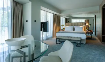a hotel room with a bed and a glass table at Altis Porto Hotel, a member of Preferred Hotels & Resorts- LVX in Porto