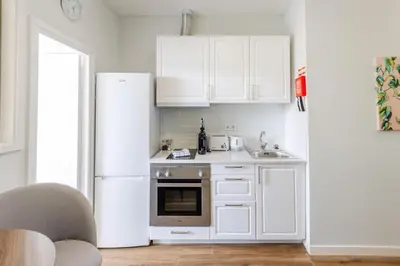 a white kitchen with a refrigerator and a sink at Porto Riverville Apartments in Porto