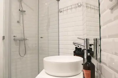 a white bathroom with a shower and a sink at Modern Flat Near Trindade by LovelyStay in Porto