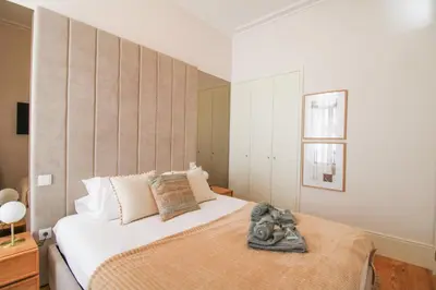 a bedroom with a large white bed and a window at Luxurious Flat in City Center by LovelyStay in Porto
