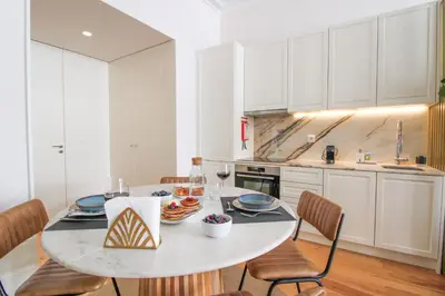 a white kitchen with a table with food on it at Luxurious Flat in City Center by LovelyStay in Porto