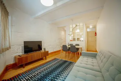 a living room with a couch and a flat screen tv at Vintage Flat by Hosty in Porto