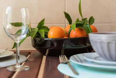 a bowl of oranges on a table with a wine glass at GuestReady - Sunny terrace in downtown Porto in Porto