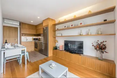 a kitchen with a table and a television in a room at ApartmentsPorto - Leisure Fun Apartment in Porto