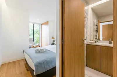 a bedroom with a bed and a bathroom with a tub at ApartmentsPorto - Leisure Fun Apartment in Porto