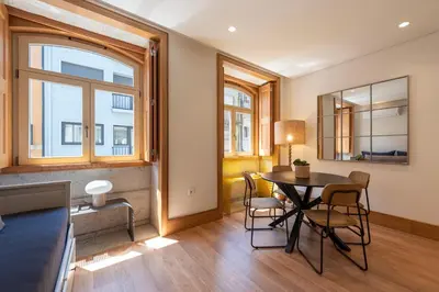 a living room with a table and chairs and a window at PortoPoint in Porto