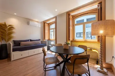 a living room with a bed and a table and chairs at PortoPoint in Porto