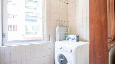 a washing machine in a bathroom with a window at Cedofeita Vintage w Free Parking by LovelyStay in Porto