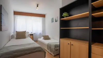 a small room with two beds and a desk at Cedofeita Vintage w Free Parking by LovelyStay in Porto