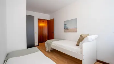 a white bedroom with a bed and a table at Cedofeita Vintage w Free Parking by LovelyStay in Porto