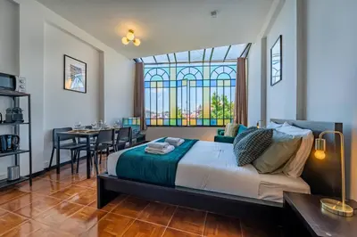 a bedroom with a bed with a table and a window at Heritage Oporto Downtown in Porto