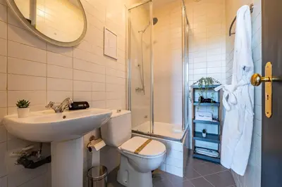 a bathroom with a sink and a toilet and a shower at Heritage Oporto Downtown in Porto