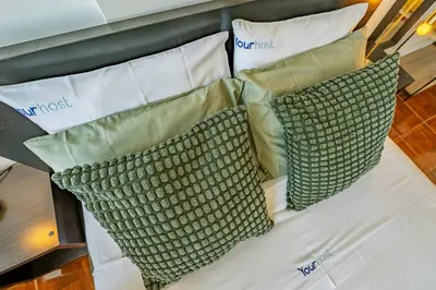 a bed with two green pillows on it at Heritage Oporto Downtown in Porto