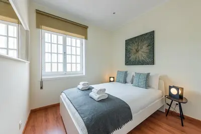 a bedroom with a large white bed with blue pillows at GuestReady - Cosy getaway in Porto in Vila Nova de Gaia