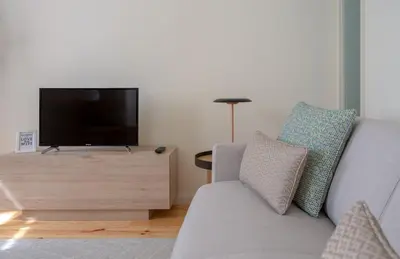 a living room with a couch and a flat screen tv at GuestReady - Catorze de Outubro Houses 427 in Vila Nova de Gaia