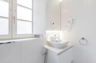 a white bathroom with a sink and a window at GuestReady - Port Studio 1 in Vila Nova de Gaia
