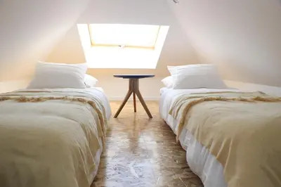 two beds in a room with a small table between them at GuestReady - Climbing Loft in Porto