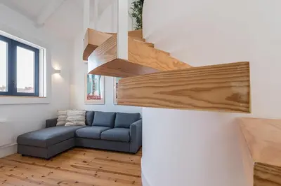 a living room with a blue couch and wooden stairs at HiddenGem - Cotton Strings in Porto