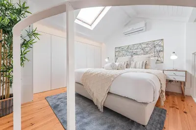 a white bedroom with a bed and a skylight at HiddenGem - Cotton Strings in Porto