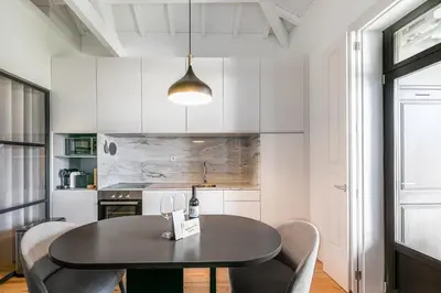 a kitchen with a black table and chairs at GuestReady - Loft 515 in Porto