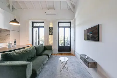 a living room with a green couch and a table at GuestReady - Loft 515 in Porto