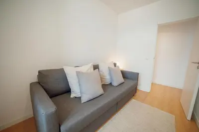 a gray couch with white pillows in a living room at Douro Panoramic Views by Vacationy in Porto