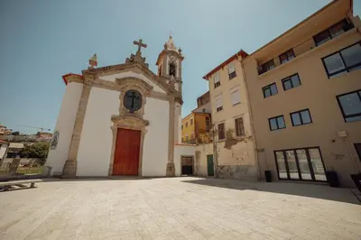 a church with a red door next to two buildings at Douro Panoramic Views by Vacationy in Porto