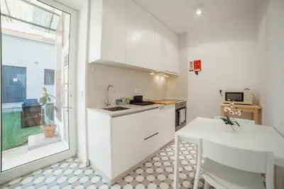 a kitchen with white cabinets and a table and a window at Douro Panoramic Views by Vacationy in Porto