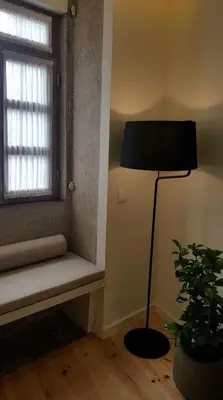 a room with a lamp and a window with a bench at GuestReady - Catorze de Outubro Houses - 387 in Vila Nova de Gaia