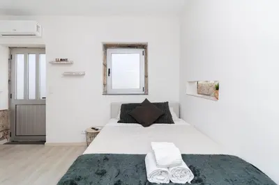 a white bedroom with a large bed with towels on it at Lady Lapa by Lady Collection in Porto