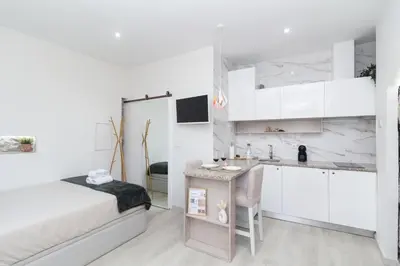 a white bedroom with a bed and a sink at Lady Lapa by Lady Collection in Porto