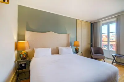 a bedroom with a large white bed and a window at Oca Flores Hotel Boutique in Porto