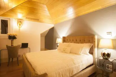 a bedroom with a bed and a desk with a laptop at Oca Flores Hotel Boutique in Porto