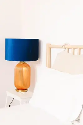 a lamp sitting on a table next to a bed at Studio Faria Guimarães in Porto