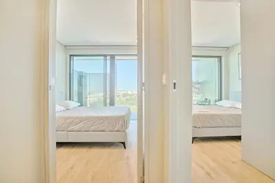 a bedroom with two beds and a window at Brand New Luxurious Ap T2 - Amazing View- with garage in Vila Nova de Gaia