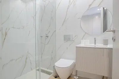 a white bathroom with a toilet and a mirror at Brand New Luxurious Ap T2 - Amazing View- with garage in Vila Nova de Gaia