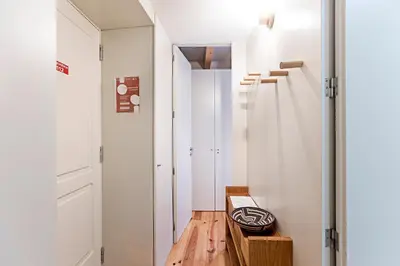 a hallway with white walls and a wooden bench at Charming Retreat with Balcony in Porto