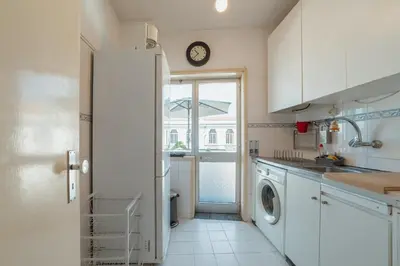 a kitchen with a washing machine and a window at Downtown Classic With Terrace by Vacationy in Porto