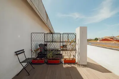 a balcony with two chairs and potted plants on it at Downtown Classic With Terrace by Vacationy in Porto
