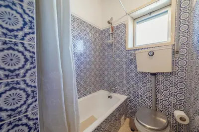 a bathroom with a tub and a toilet and a window at Downtown Classic With Terrace by Vacationy in Porto