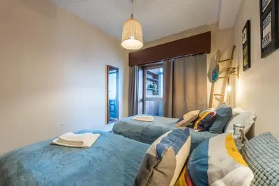 a bedroom with two beds and a pendant light at Woodwork Apartment in Porto
